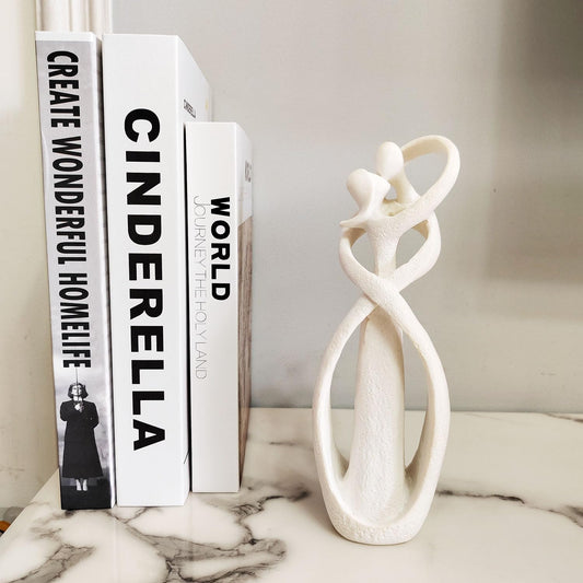 Decorative books with text and a white marble sculpture on a surface.
