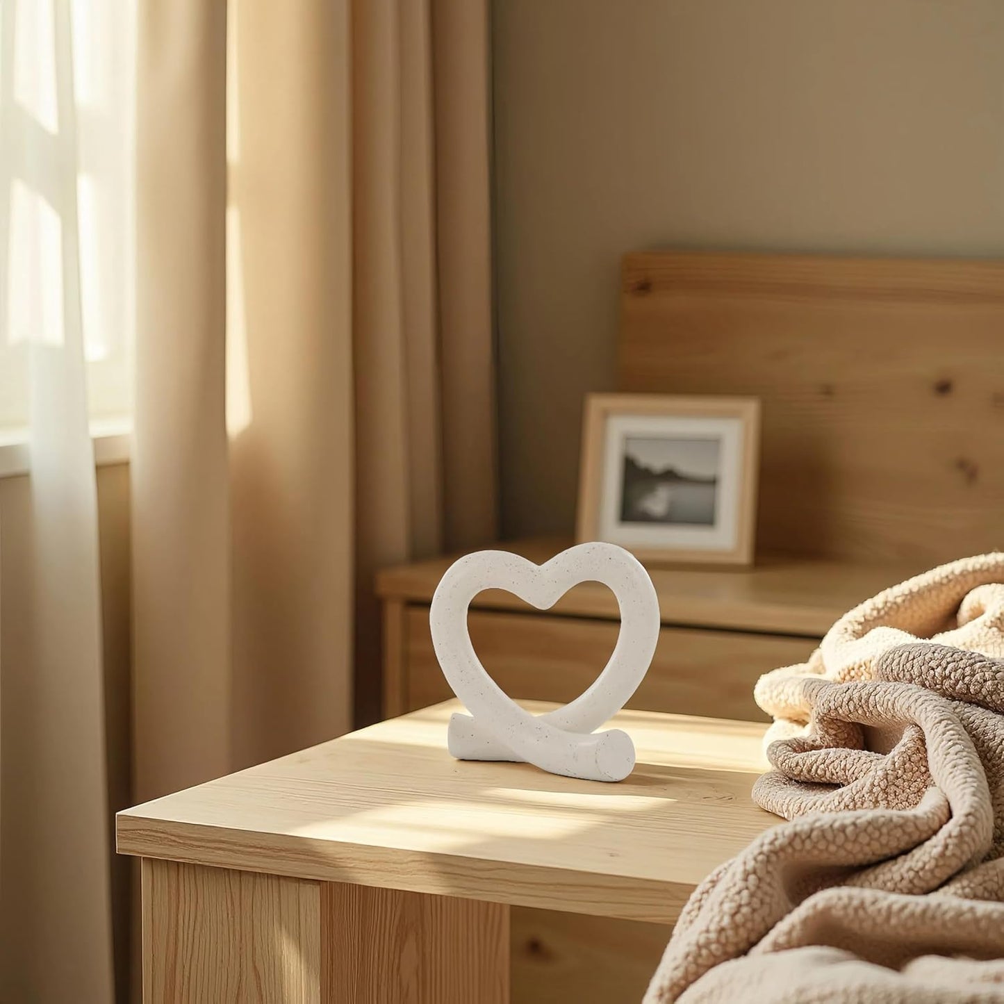 Decorative heart-shaped object on a wooden surface with a cozy room setting.
