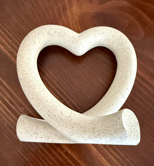 Heart-shaped ceramic object on a wooden surface