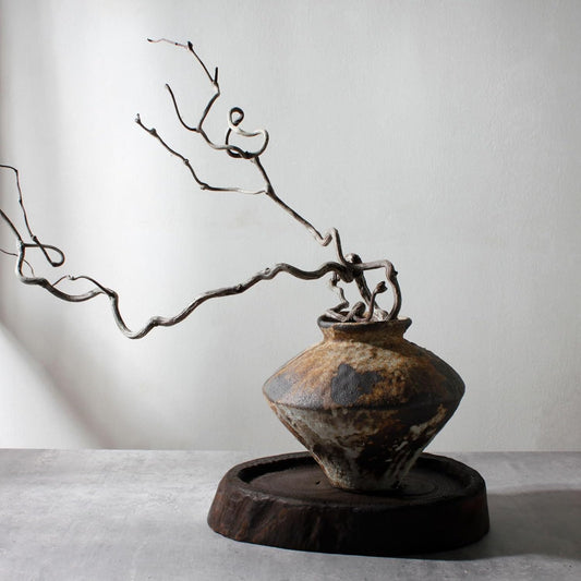 Vintage pot with a branch on a neutral background
