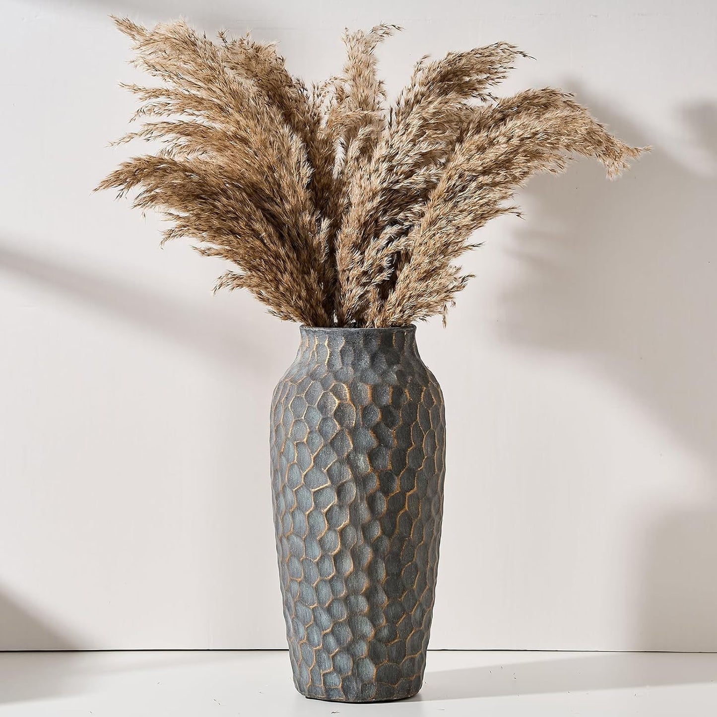 Textured vase with dried pampas grass against a neutral background