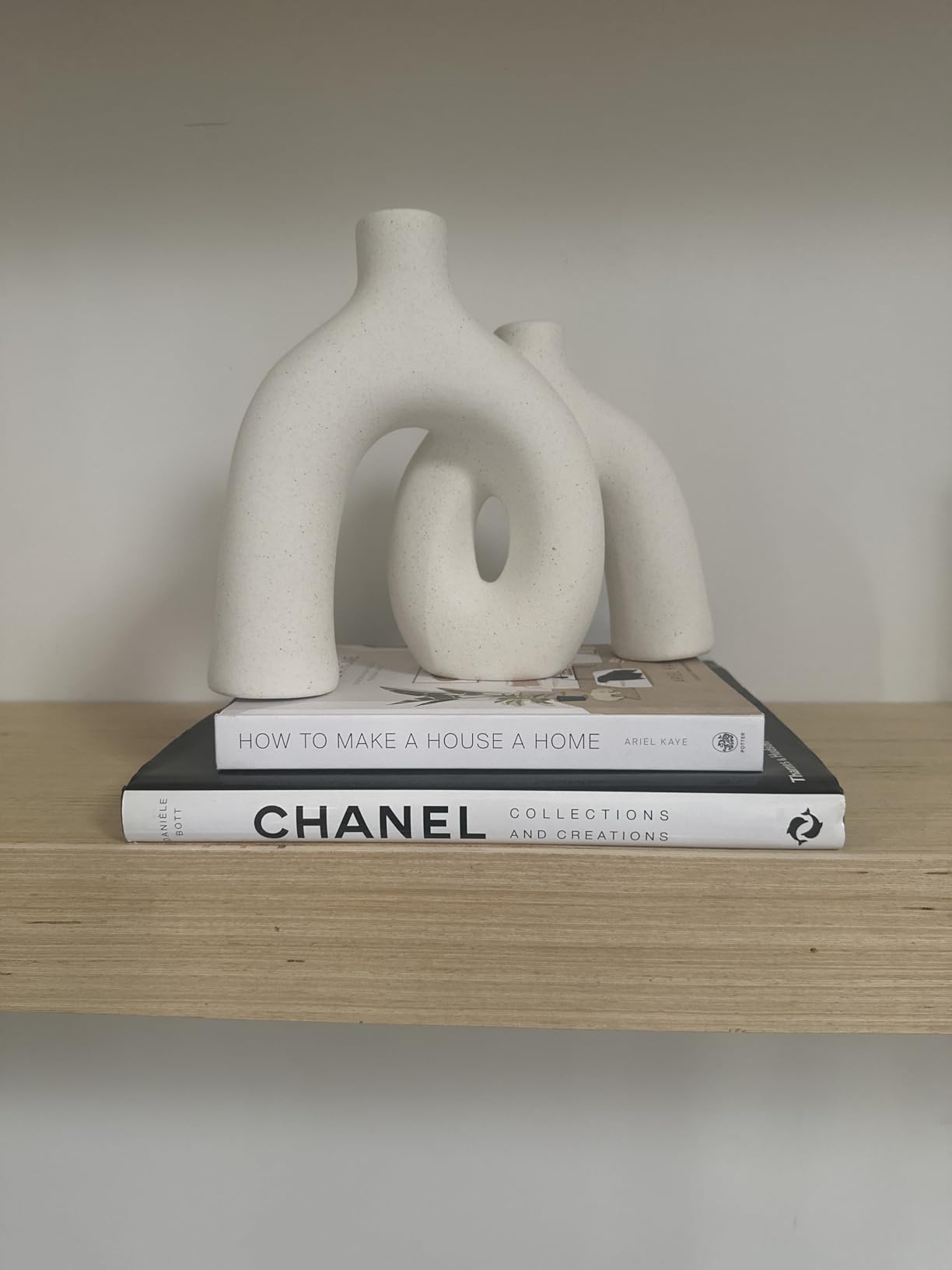 White abstract sculpture on top of books with a blurred background