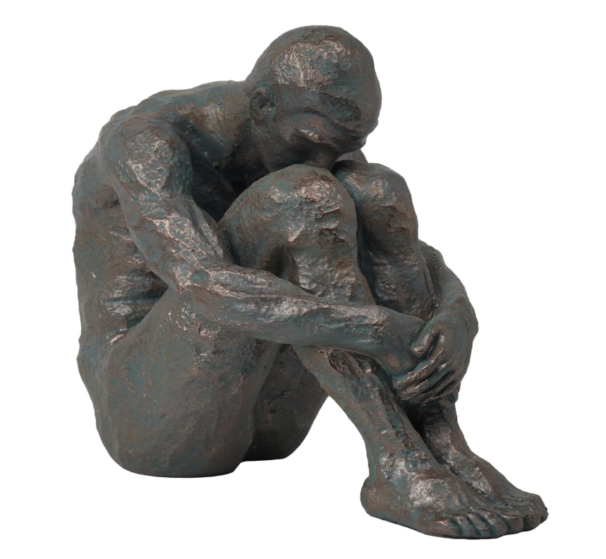 Bronze sculpture of a seated figure on a white background