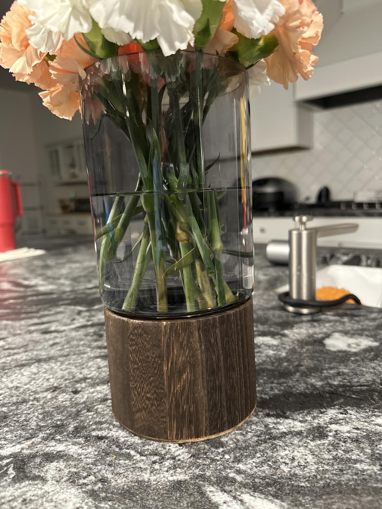 Clear vase with flowers on a kitchen counter