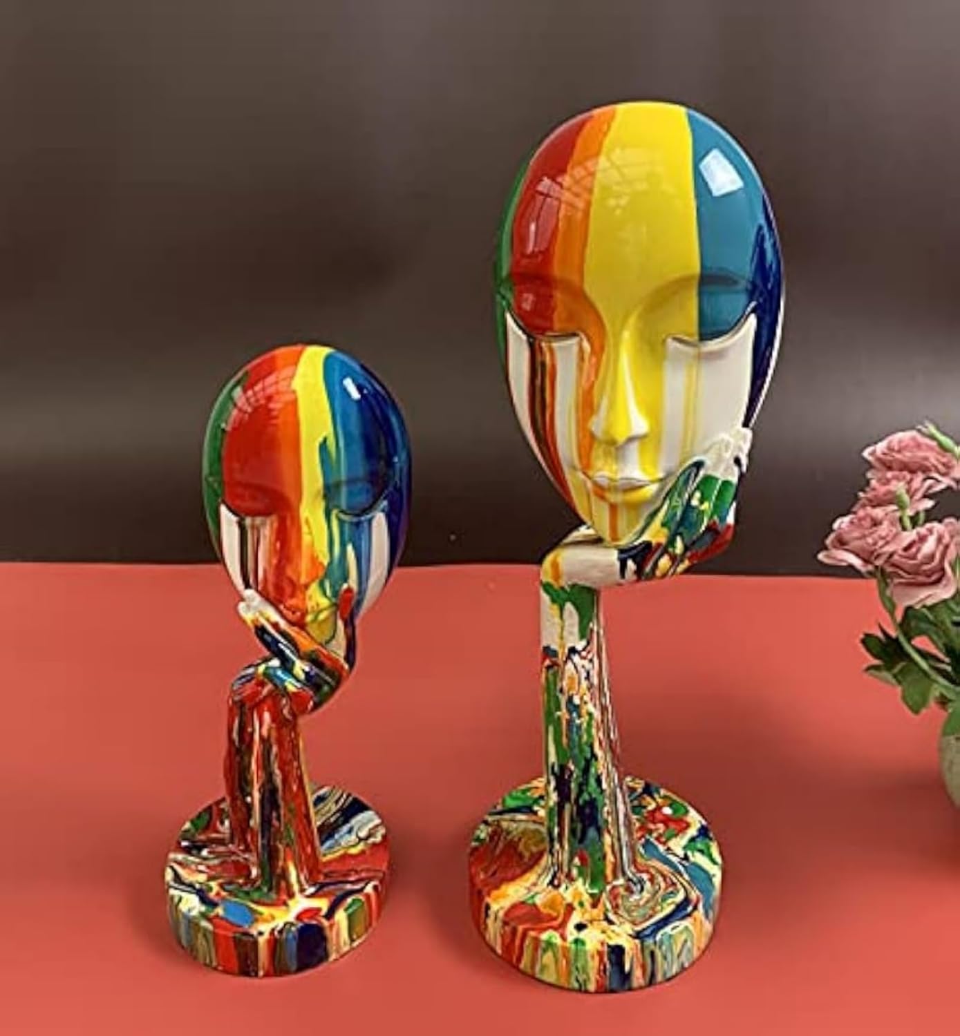 Colorful abstract sculpture of a face on a stand with a dark background