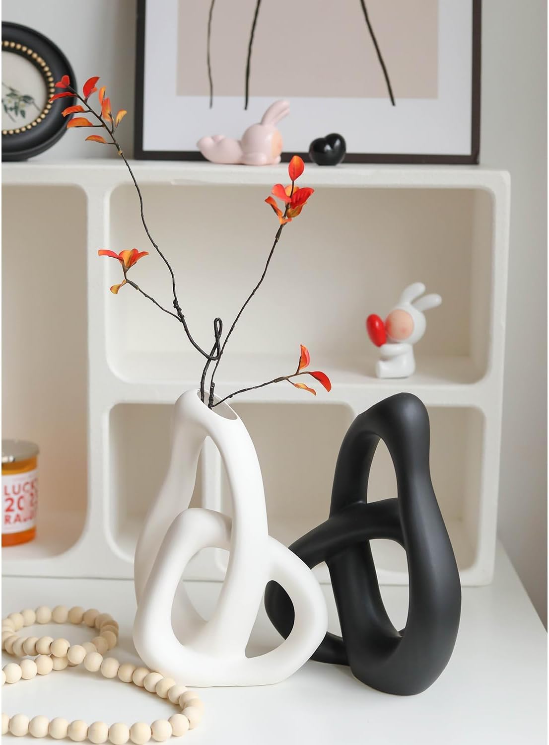 Decorative black and white vases with a shelf in the background
