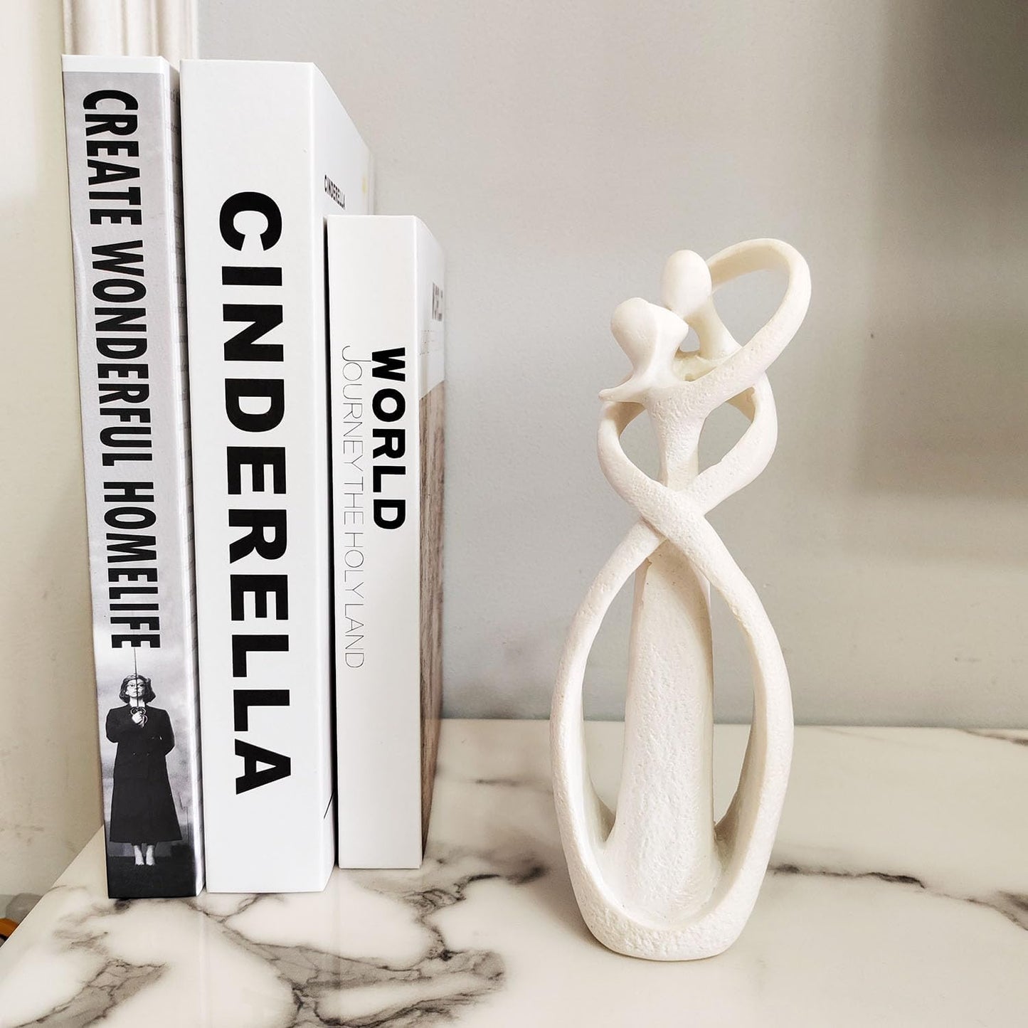 Decorative books with text and a white marble sculpture on a surface.