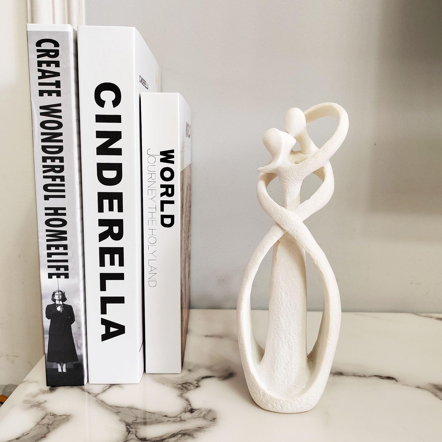Decorative books with text and a white marble sculpture on a surface.