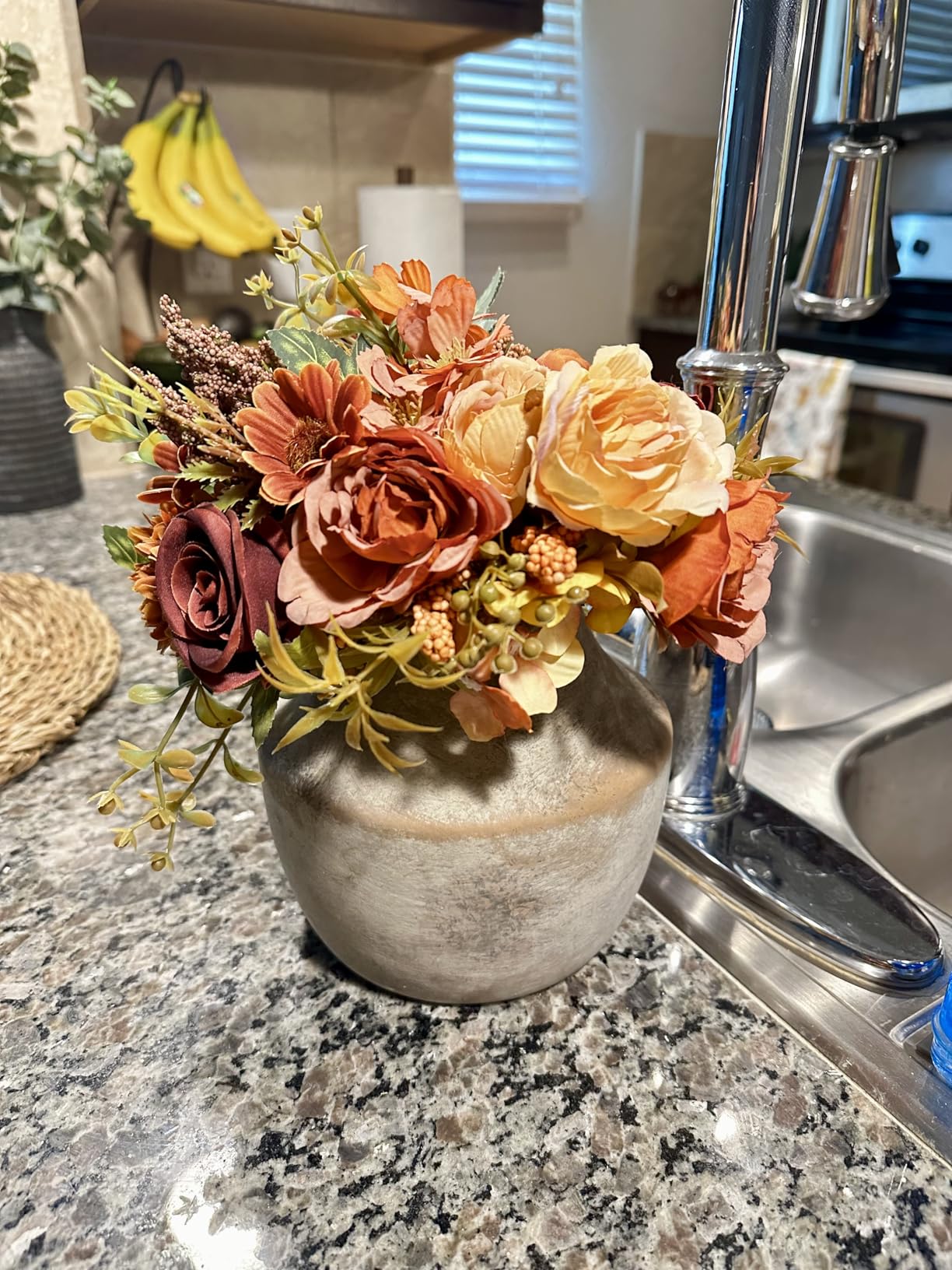 Decorative floral arrangement in a vase on a kitchen counter.