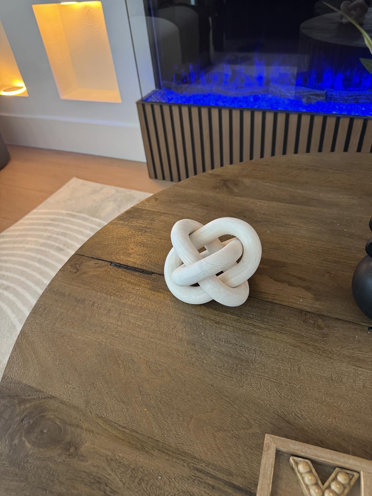 Decorative knot sculpture on a wooden table with a blurred background