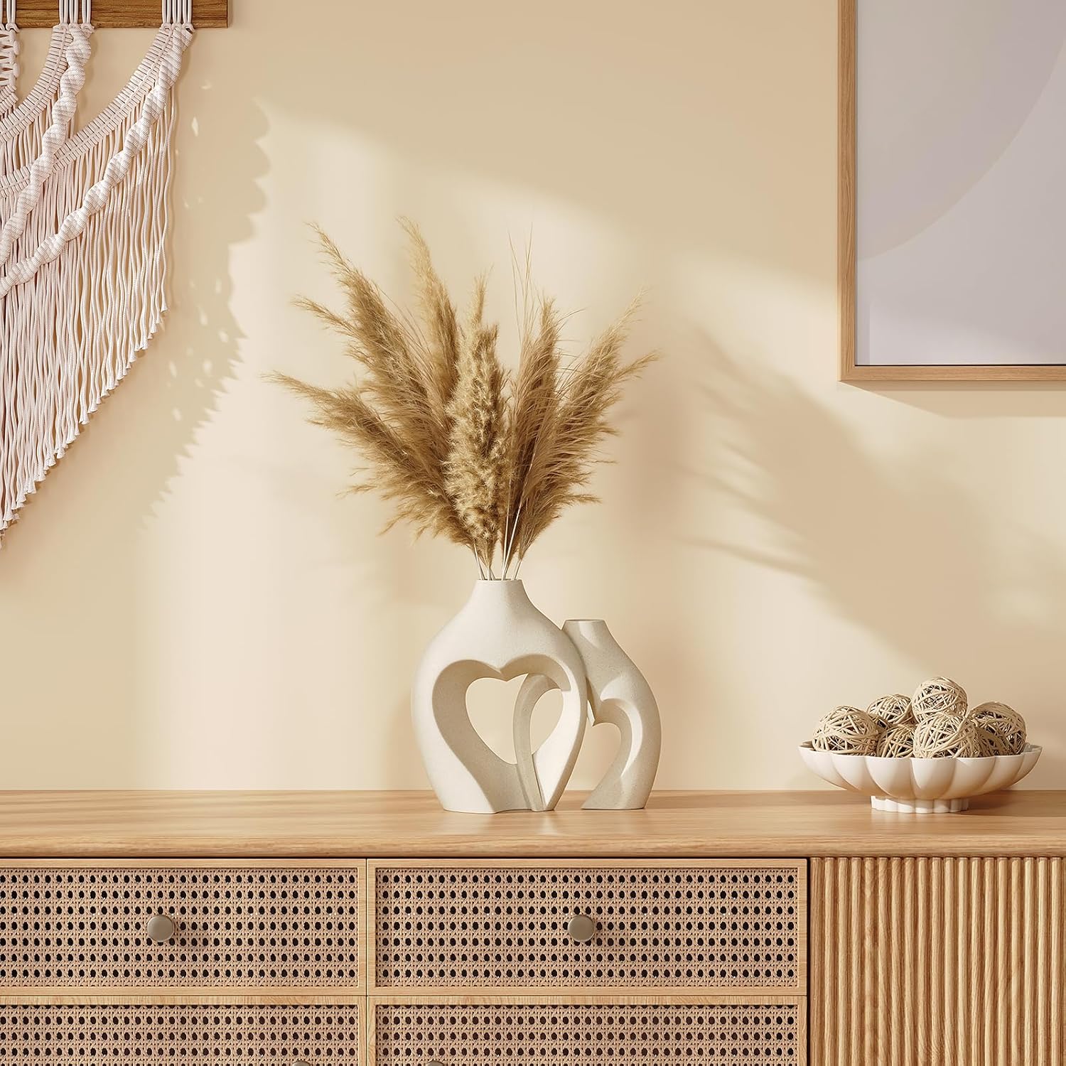 Decorative setting with a vase holding dried plants on a wooden surface.