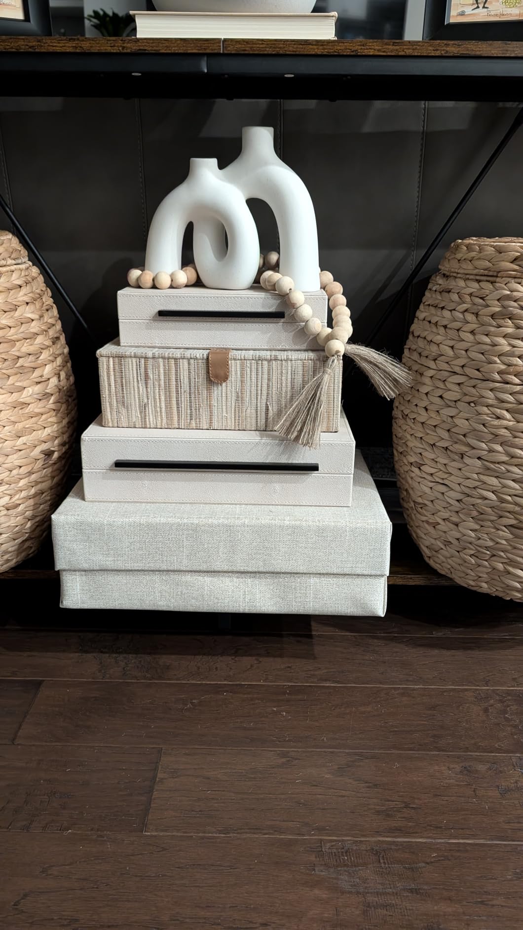 Decorative stack of boxes with a white vase on top, set against a dark background.