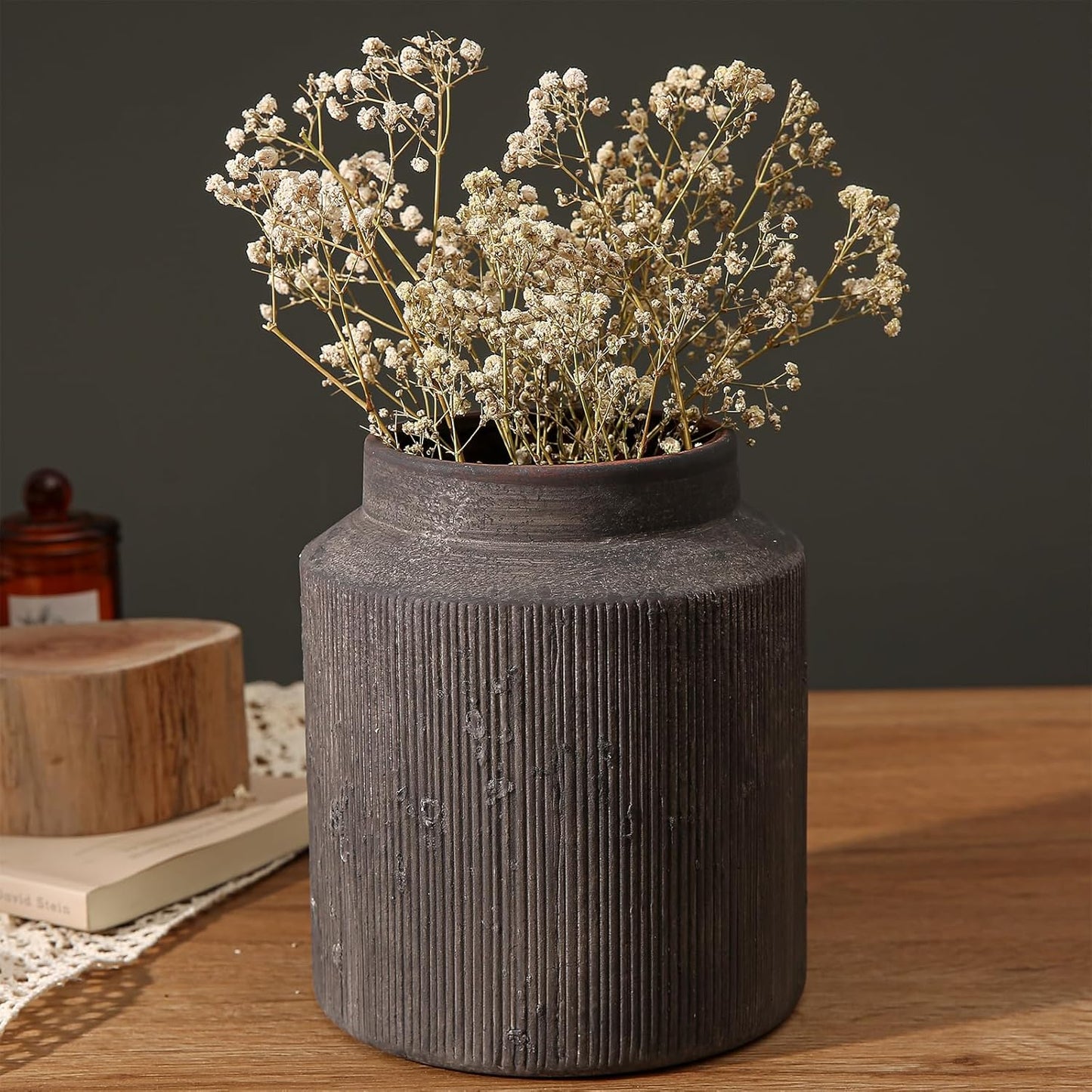 Decorative vase with dried flowers on a wooden surface