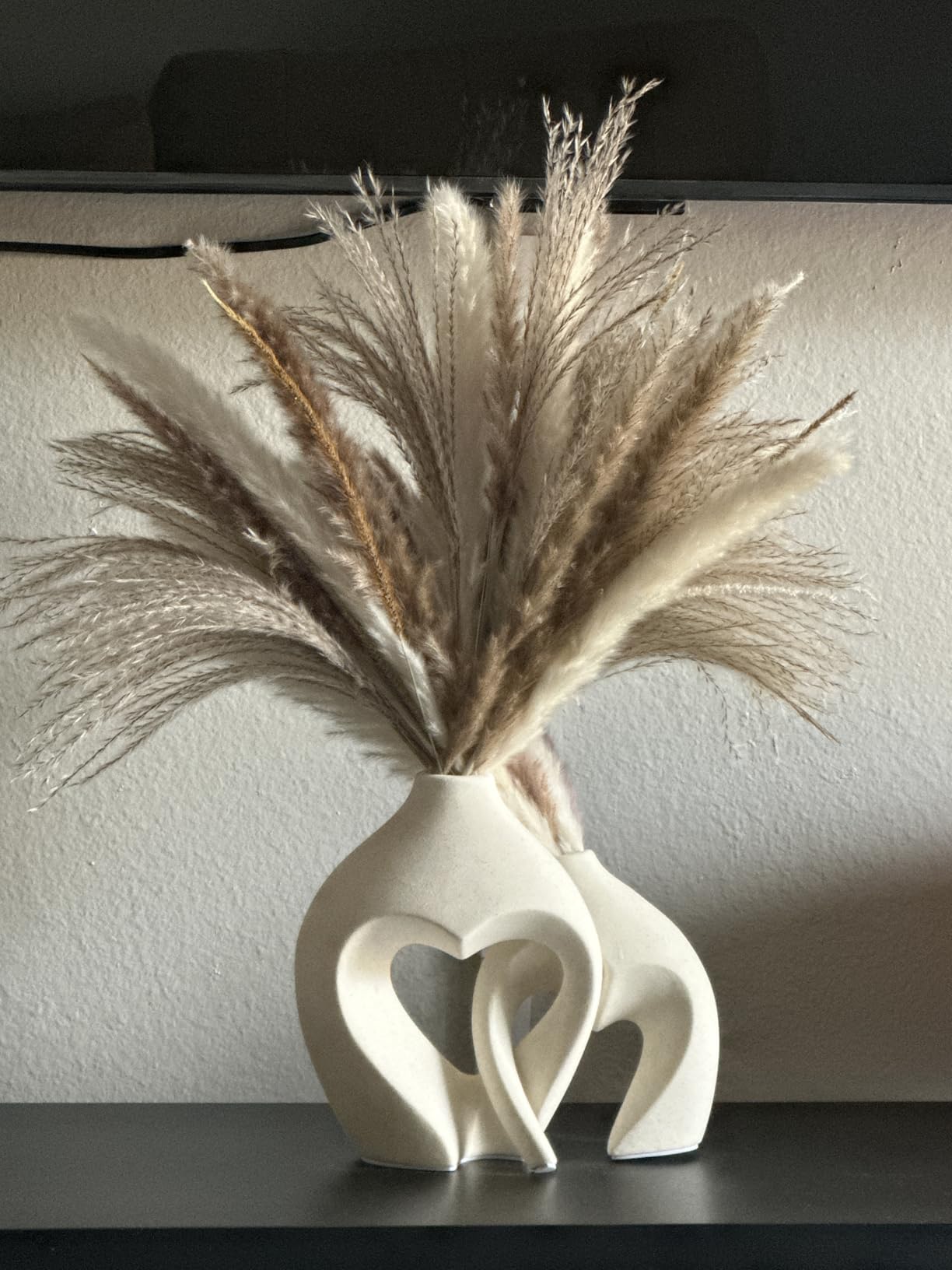 Decorative vase with dried pampas grass against a neutral background