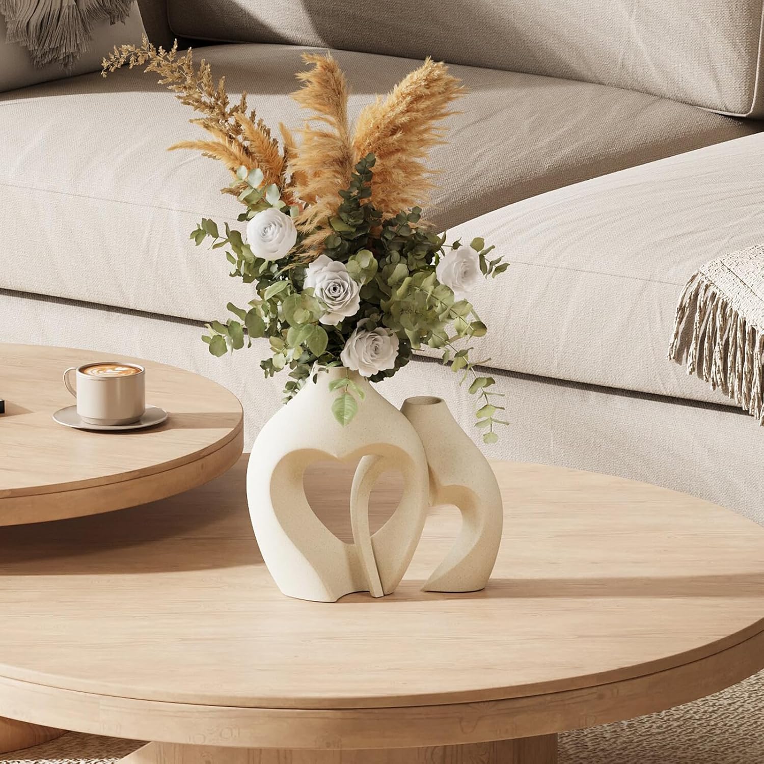 Decorative vase with flowers on a wooden coffee table in a living room setting.