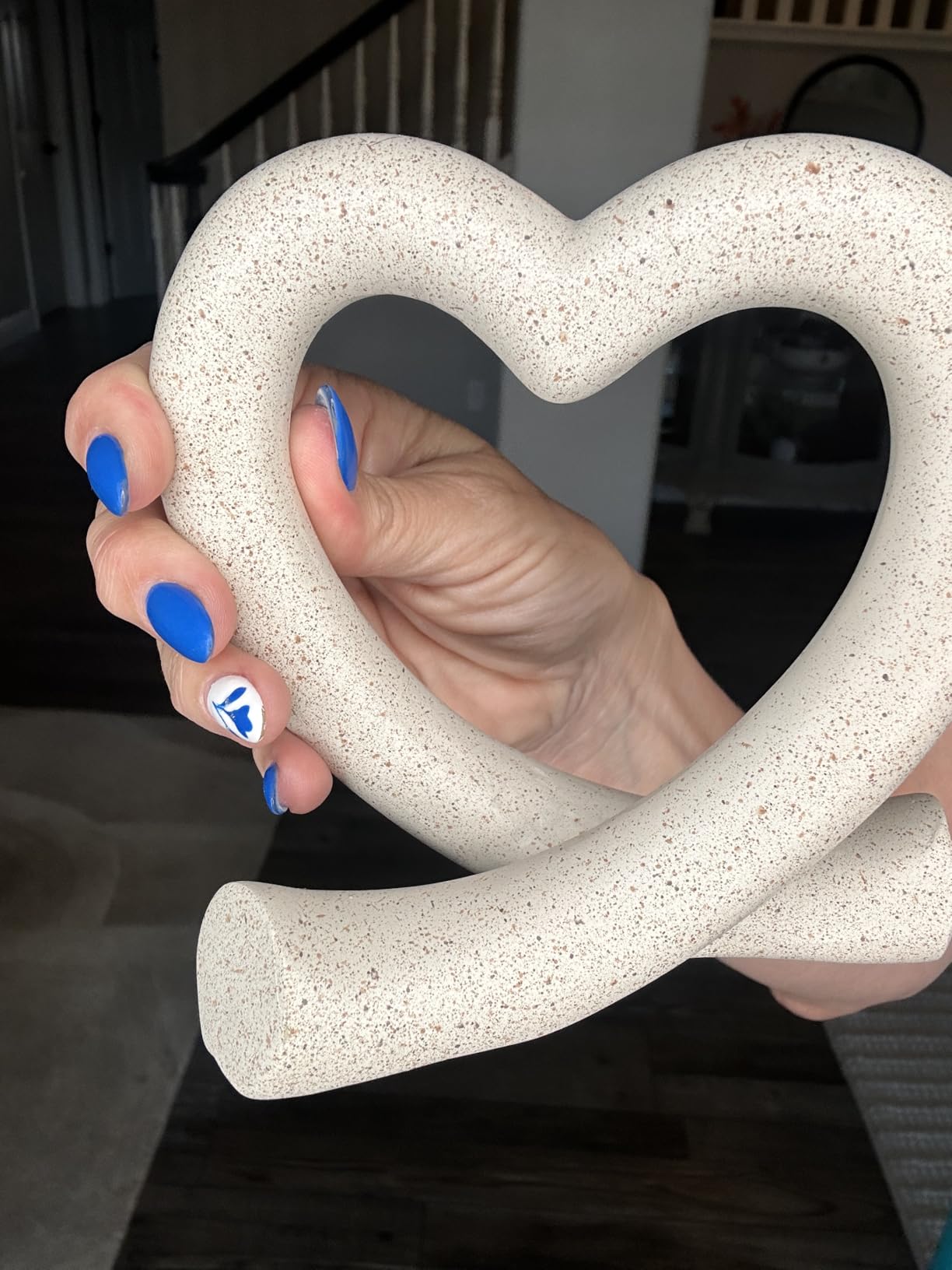 Hand holding a heart-shaped object with speckled texture