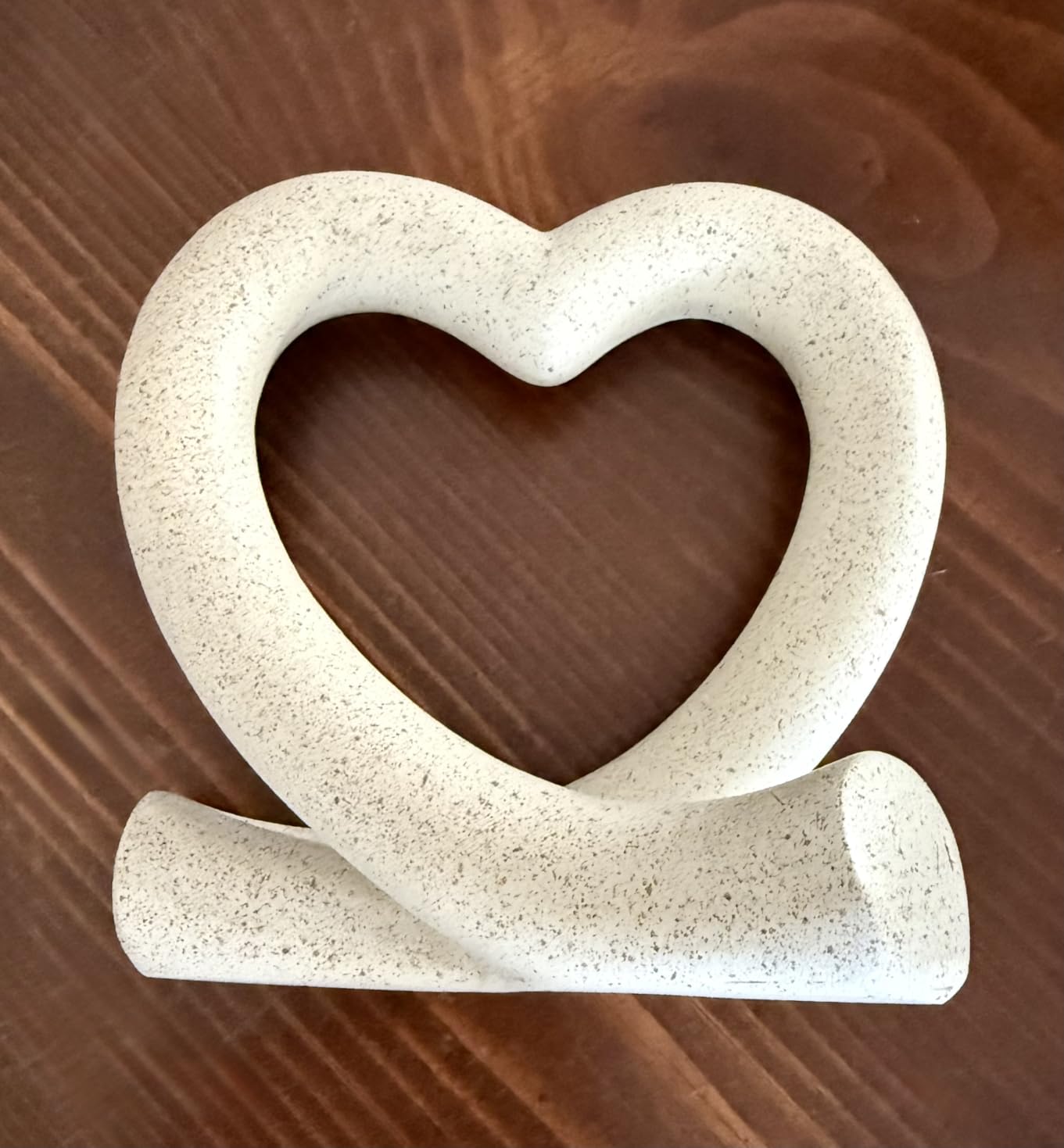 Heart-shaped ceramic object on a wooden surface
