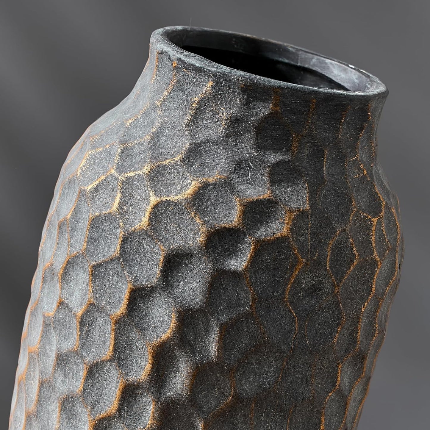 Textured black ceramic vase on a gray background