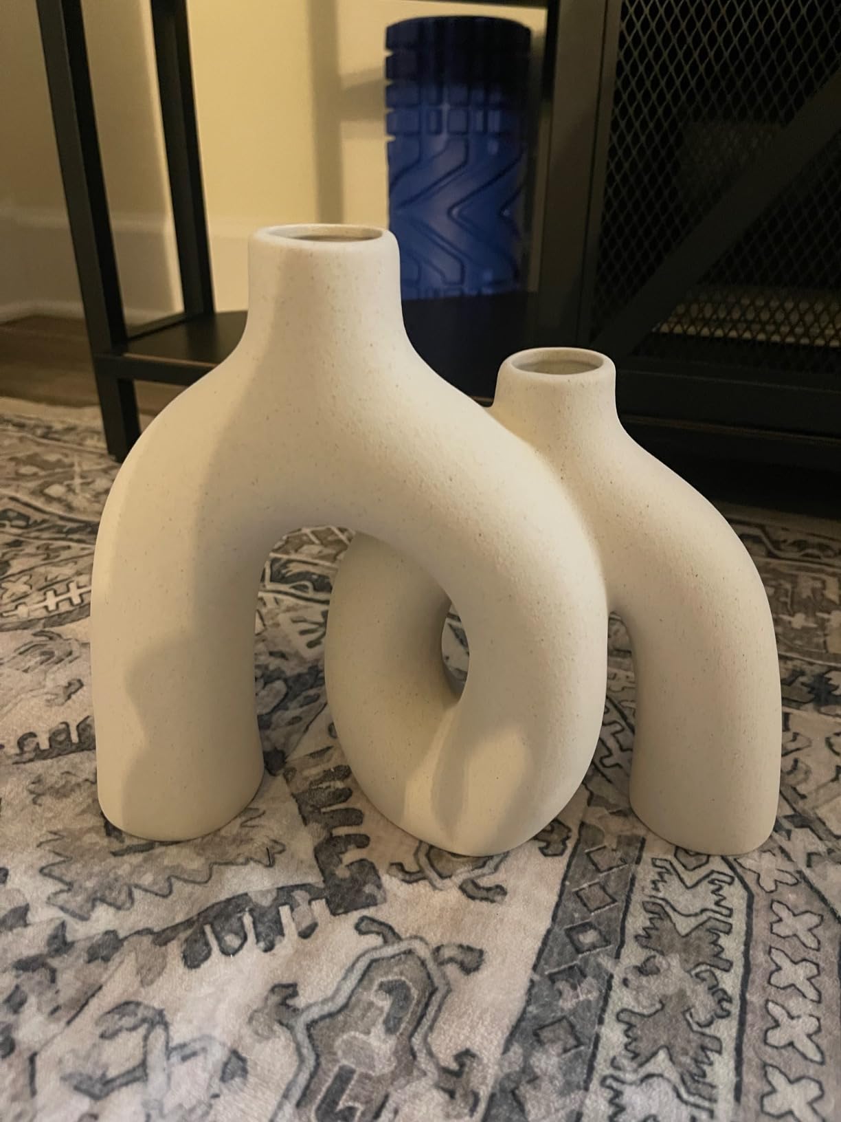 Three white ceramic vases on a patterned rug