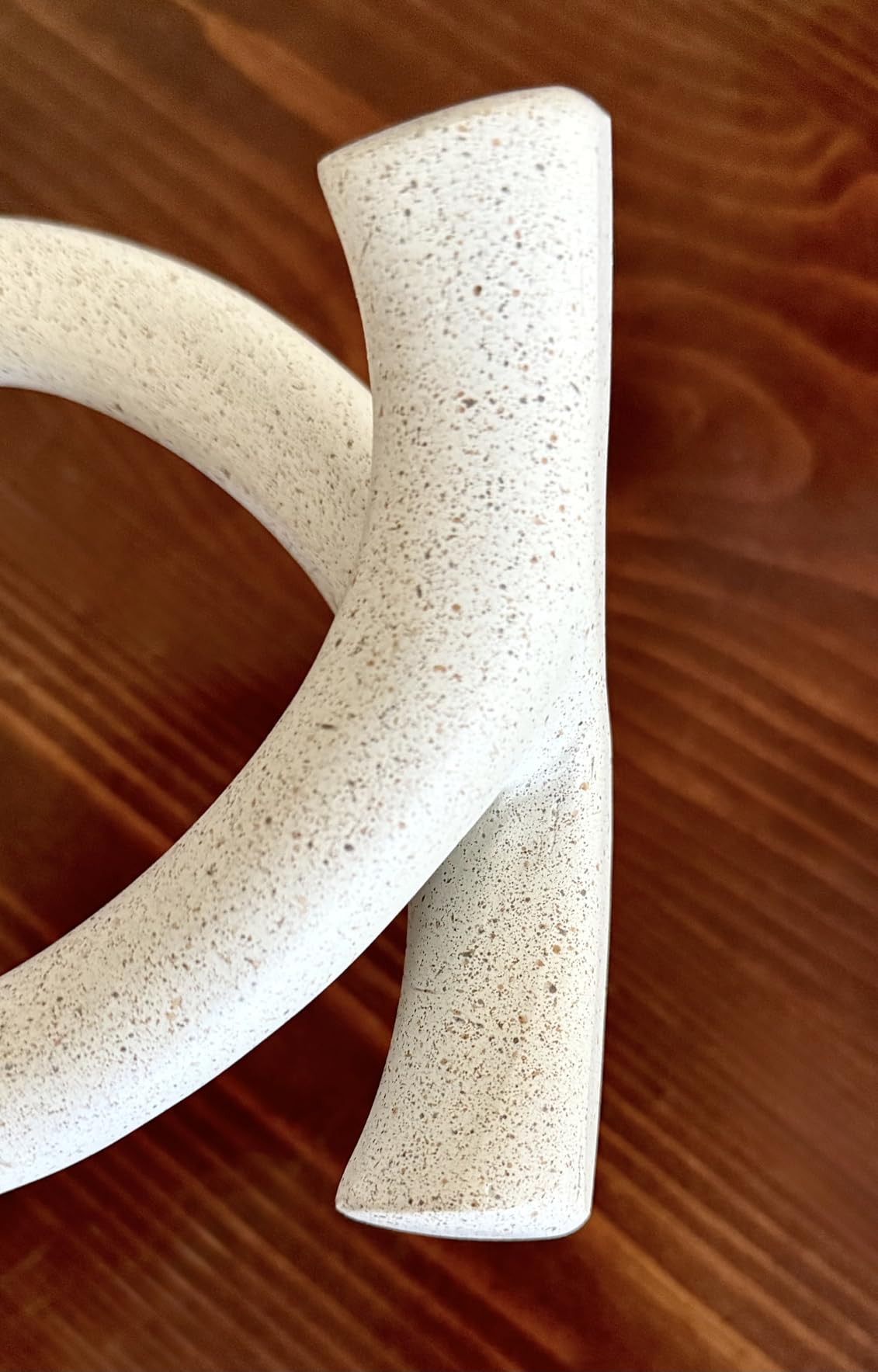 Two white ceramic handles on a wooden surface
