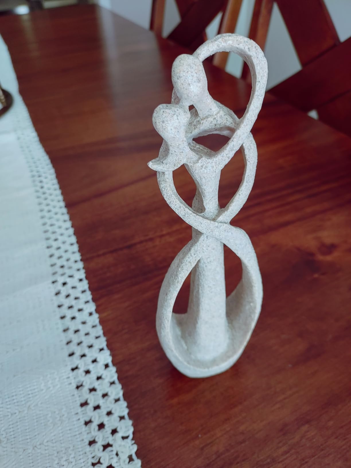 White ceramic sculpture of a couple on a wooden table