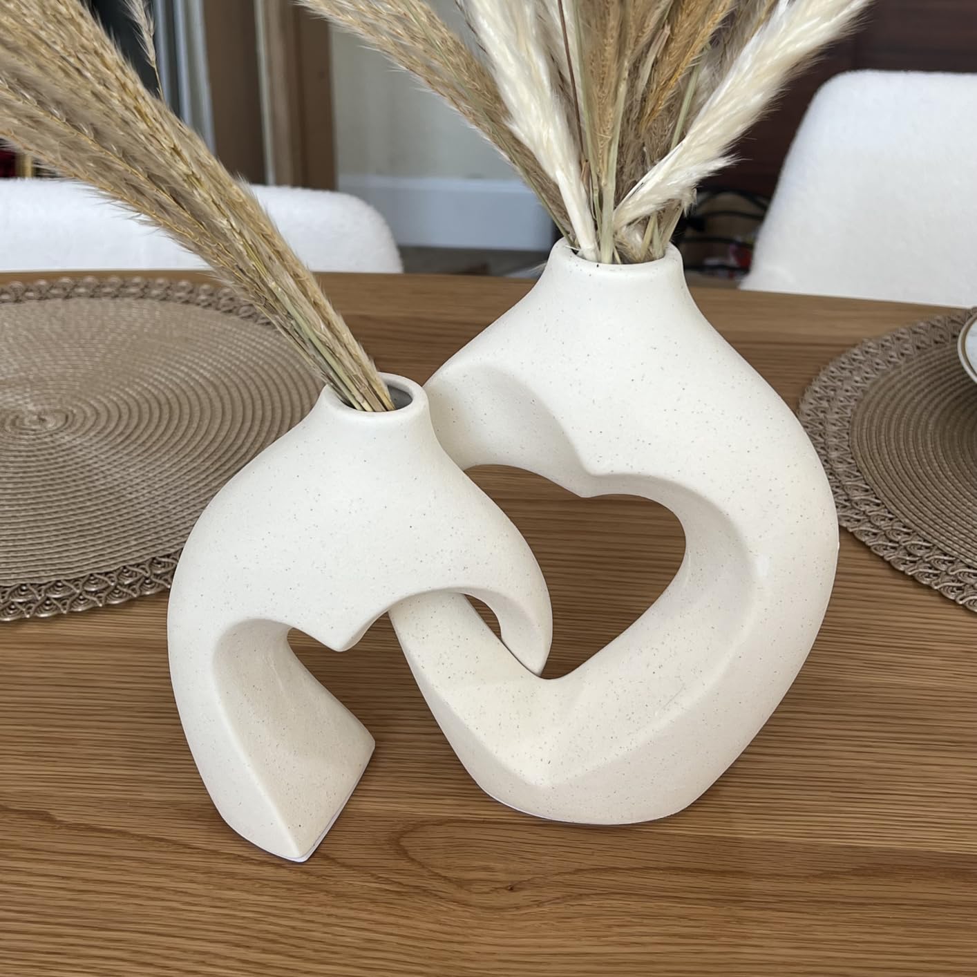 White ceramic vase with heart design on a wooden surface